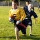 A young flag football player goes for the touchdown.
