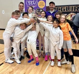 IMG_0372 Rochester, MN Fencing Club holds up their first place trophy at the May 2024 fencing tournament.