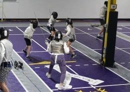 Fencing club with fencers fencing.